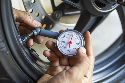 thợ đang đo áp suất lốp xe mô tô thợ đang đo áp suất lốp xe mô tô